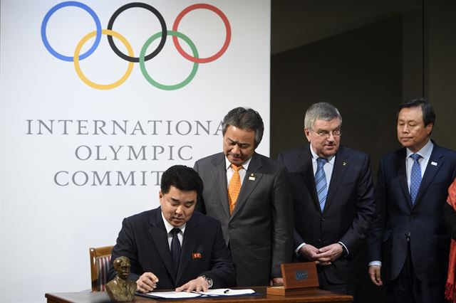 지난달 20일 오전(현지시간) 스위스 로잔의 국제올림픽위원회(IOC) 본부에서 토마스 바흐 IOC 위원장과 도종환 문화체육관광부 장관이 지켜보는 가운데 김일국 북한 체육상 겸 민족올림픽위장이 남북 올림픽 역사상 첫 남북 단일팀을 구성하는 합의서에 서명을 하고 있다. 로잔=AP연합뉴스