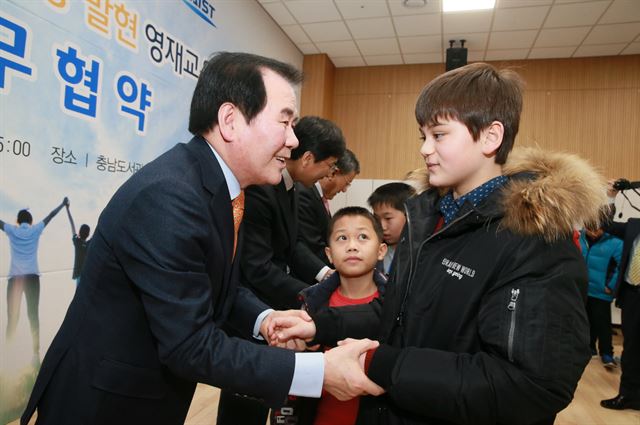 충남교육청이 21일 전국 최초로 다문화영재교육원을 개설했다. 김지철 교육감이 예비다문화 영재학생으로 선발한 학생의 손을 잡고 격려하고 있다. 충남도교육청 제공