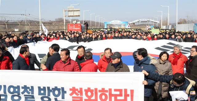 자유한국당 의원들과 보수단체 회원들이 25일 오전 파주 통일대교 남단에서 김영철 방남 반대 집회를 하다 김영철이 다른 경로로 이동했다는 소식이 전해진 후 태극기를 펼치고 행진하며 통일대교를 떠나고 있다. 파주=연합뉴스