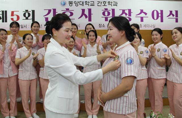 동양대학교가 간호학과 졸업생들에게 간호사 휘장을 달아 주고 있다. 동양대 제공