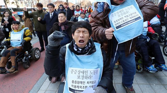 지난해 12월 1일 오후 서울 영등포구 이룸센터 앞에서 열린 장애인권리보장법연대 출범식 및 결의대회에서 한국장애인단체총연맹과 전국장애인차별철폐연대 회원들이 구호를 외치고 있다. 연합뉴스