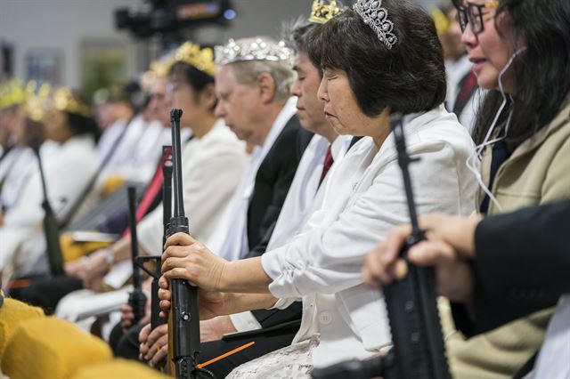 28일 (현지시간)미국 펜실베이니아주 뉴파운드랜드 ‘세계평화통일안식처’ (World Peace and Unification Sanctuary) 일명 ‘생추어리 처치’에서 열린 합동결혼식에서 커플들이 AR-15소총을 비롯해 다양한 총으로 무장한 채 결혼식을 올리고 있다. 펜실베이니아=EPA연합뉴스