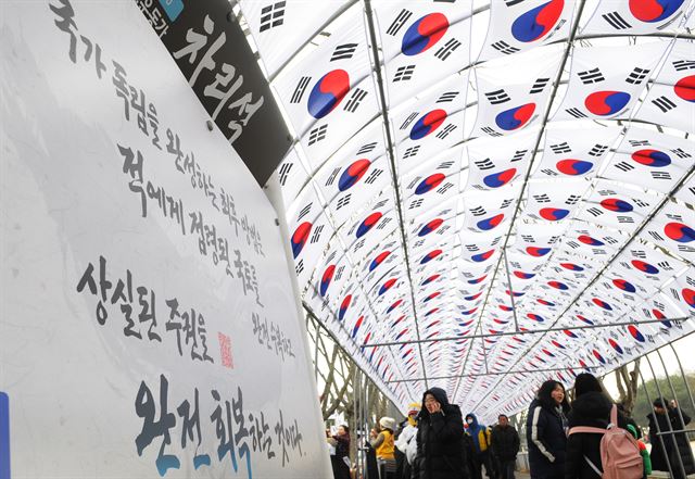 [저작권 한국일보] 1일 천안 독립기념관에서 열린 제99주년 3ㆍ1절 기념식에 참석한 사람들이 애국지사들의 어록을 전시한 태극기 터널을 지나고 있다. 이준호 기자