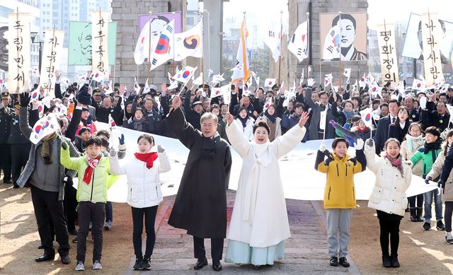 문재인 대통령과 부인 김정숙 여사가 1일 오전 제99주년 3ㆍ1절을 맞아 서울 서대문형무소 역사관에서 독립문까지 대형 태극기를 들고 행진한 뒤 참석자들과 함께 만세 삼창을 하고 있다. 연합뉴스