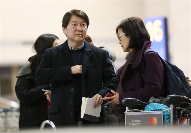 안철수(왼쪽) 국민의당 전 대표가 2일 오후 인천국제공항 입국장에서 짐을 기다리며 부인인 김미경 교수와 대화하고 있다. 영종도=연합뉴스