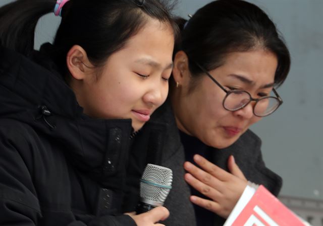 한국지엠 군산공장 근로자의 아내와 딸이 지난 27일 전북 군산시청 앞에서 열린 '한국지엠 군산공장 폐쇄 철회를 위한 군산시민 결의대회'에 참석해 고개를 숙이며 '폐쇄 철회를 위해 노력해달라'며 호소하고 있다. 뉴스1