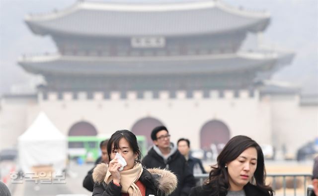 서울과 수도권 대부분 지역의 미세먼지 농도가 '나쁨'을 나타낸 27일 오후, 서울 광화문 네거리를 지나던 한 시민이 휴지로 코를 막고 있다. 서재훈기자