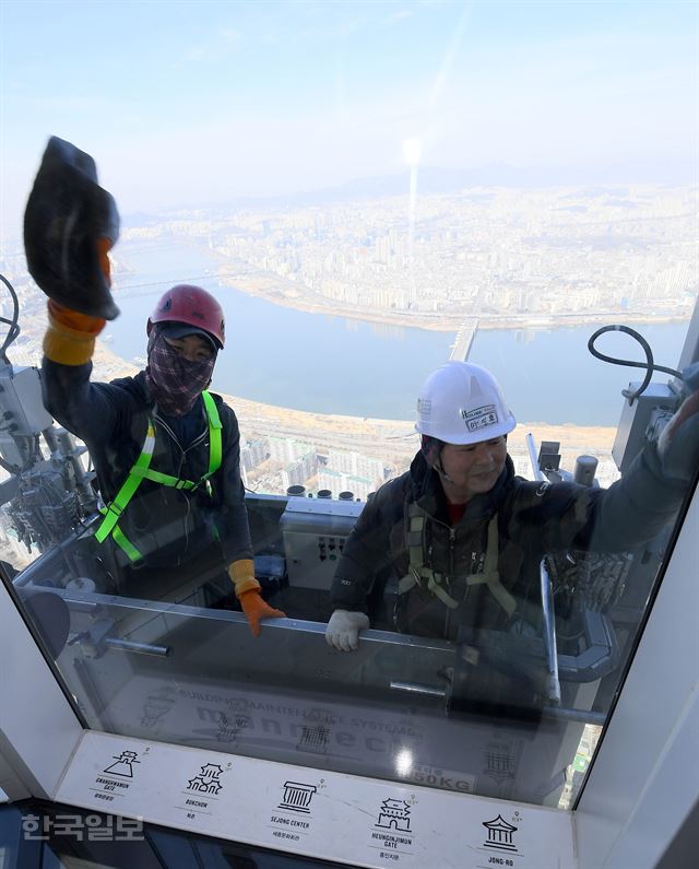 [저작권 한국일보]롯데월드타워 봄맞이 청소경칩인 6일 오전 서울 송파구 롯데월드타워에서 전문 고소작업자들이 유리 외벽을 청소하고 있다. 이날 시작된 롯데월드타워 123개 층의 약 4만2천여 장의 청소 시간은 약 700시간이 걸릴 것으로 예상된다. 하루 8시간 작업하는 것으로 가정해 날수로 환산하면 약 90일이 걸리는 대규모 청소 작업이다. 서재훈기자