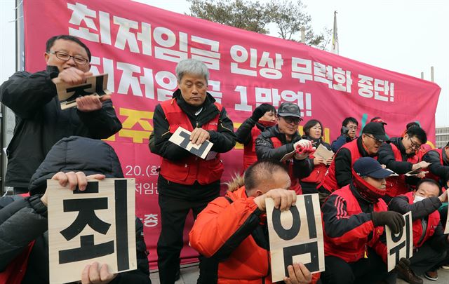 지난 달 20일 오후 정부세종청사 최저임금위원회 앞에서 열린 최저임금인상 무력화 중단 촉구·최저임금 1만원 보장 결의대회에서 민노총 관계자들이 '최저임금 무력화 꼼수, 최저임금 산입범위 확대, 최임위(최저임금위원회) 기울어진 운동장'이라고 적힌 송판을 부수고 있다. 세종=연합뉴스