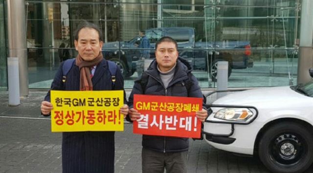 박재만 전북도의원(왼쪽)과 장현철 한국GM 군산공장 사내 비정규직 근로자 비상대책위원장이 12일 (현지시간) 미국 GM 본사 앞에서 군산공장 정상가동을 촉구하고 있다. 박재만 전북도의원 제공