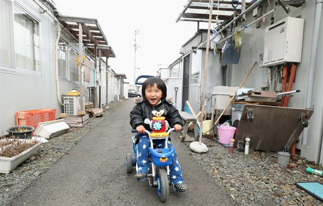 동일본대지진 7년을 하루 앞둔 지난 10일 이와테(岩手)현 오쓰치초(大槌町)의 재난 피해자 대상 가설주택 마을에서 남자 아이가 웃는 얼굴로 놀고 있다. 오스치초(일본 이와테현)=교도 연합뉴스