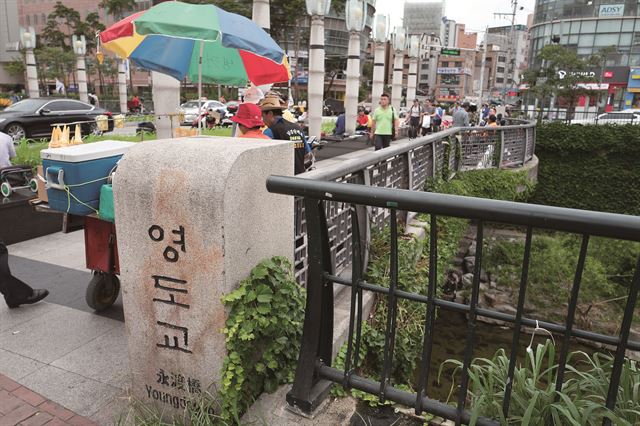 서울 숭인동과 황학동 사이 청계천 위에 걸쳐 있던 다리인 영도교 머릿돌. 폐위된 17세의 단종과폐서인된 18세의 부인 정순왕후 송씨가 생이별한 장소로 알려져 있다. 빨간 페인트 스프레이 자국이 흉하게 남아 있다. 최수연 작가