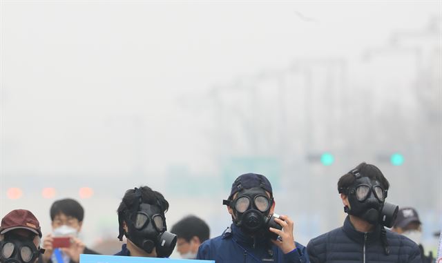 서울과 수도권 지역에 미세먼지 비상저감조치가 시행된 26일 오전 서울 광화문 거리에서 미세먼지 줄이기를 위한 시민 주도 캠페인 참가자들이 방독면을 착용하고 있다. 연합뉴스