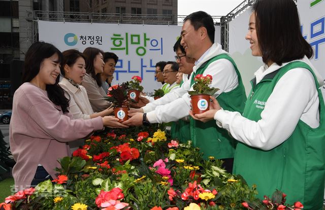 대상 청정원과 한국산림복지진흥 임직원들이 27일 오전 서울 청계광장에서 열린 '2018 희망의 나무나누기' 행사에서 시민들에게 묘목을 나누어 주고 있다. 2018.03.27.신상순 선임기자