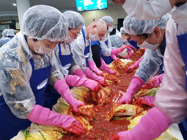 삼성전자 스마트시티 임직원과 자원봉사자들이 지역 내 저소득 가정에게 전달할 김치를 담그고 있다. 구미시 제공