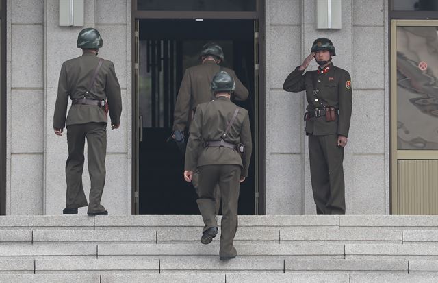 28일 판문점 남측 지역을 살핀 북한 경비병들이 북측 지역 건물로 들어가고 있다. 판문점=연합뉴스