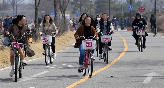 25일 한강시민공원 여의도지구에서 헬멧을 쓰지 않은 대여용 자전거 이용자들이 자전거도로를 달리고 있다.