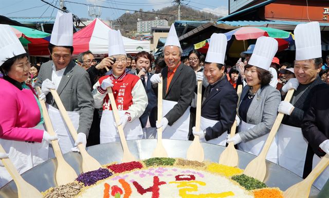 하동공설시장에서는 7, 8일 상큼한 봄맛을 느낄 수 있는 ‘알프스 하동 봄나물 축제’가 열린다. 지난해 축제에서 윤상기(오른쪽서 네 번째) 군수와 상인들이 500인분의 대형 봄나물비빔밥 퍼포먼스를 벌이고 있다. 하동군 제공