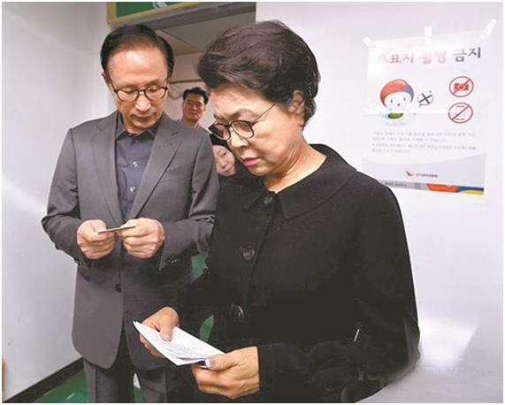 이명박 전 대통령과 부인 김윤옥 여사가 19대 대선 투표일인 지난해 4월 9일 서울 강남구 논현1동 제3투표소를 찾아 선거인 명부 확인을 위해 줄을 서 있다. 한국일보DB