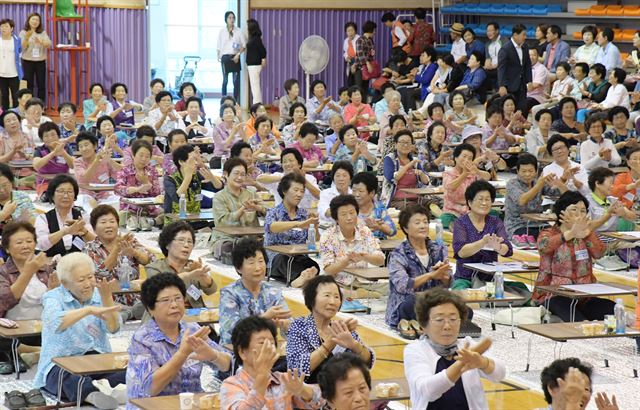 지난해 9월 논산시 국민체육센터에서 열린 ‘2017 어르신 한글 백일장’에 참가한 할머니들이 백일장 시작 전 흥을 돋우는 율동을 하고 있다. 논산시 제공