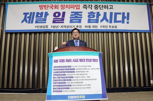 우원식 더불어민주당 원내대표가 18일 국회에서 열린 의원총회에서 10대 민생법안을 발언대에 부착하고 야당에 국회정상화를 촉구하고 있다. 연합뉴스