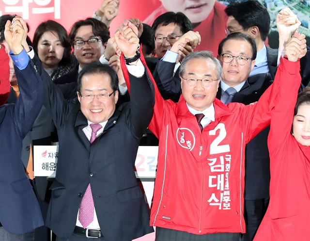 홍준표(왼쪽) 자유한국당 대표가 18일 오후 부산 해운대구 반여동에서 열린 김대식 해운대을 국회의원 예비후보 사무소 개소식에 참석해 김 예비후보와 함께 손을 들어 올리고 있다. 부산= 연합뉴스