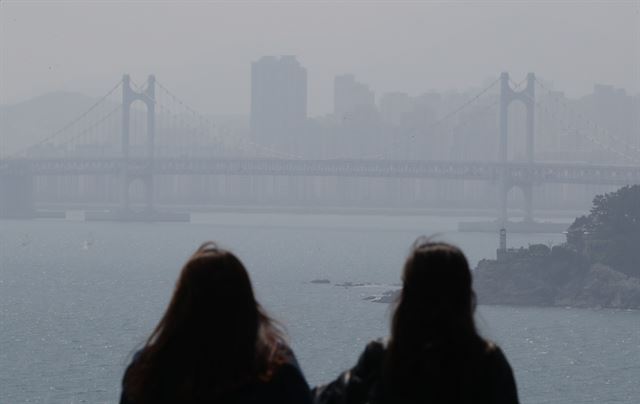 18일 부산 해운대 달맞이언덕에서 나들이객이 미세먼지 때문에 뿌연 광안대교를 바라보고 있다. 부산은 이날 미세먼지농도가 나쁨 수준을 보였다. 부산=연합뉴스