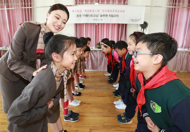 18일 중국 저장성 닝보시 인저우구 탕시진중심소학과 '아름다운 교실' 자매 결연을 맺은 뒤 아시아나항공 승무원이 직업 특강에서 학생들에게 인사법을 교육하고 있다. 아시아나항공 제공.