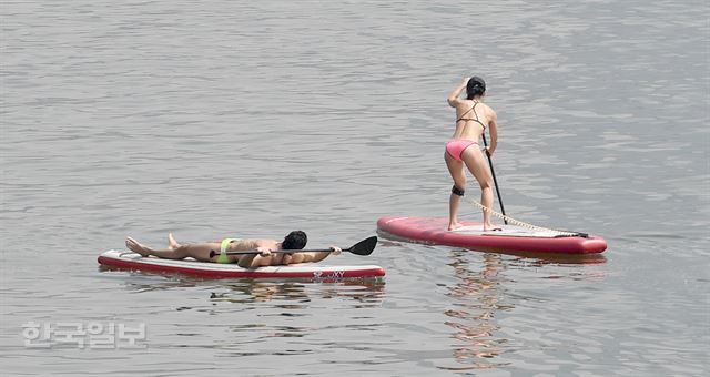 서울 낮 기온이 27도까지 올라간 20일 오후 서울 광진구 뚝섬 한강공원에서 비키니 차림의 패들보드 동호회원들이 갑자기 찾아온 더위를 즐기고 있다. 서재훈기자