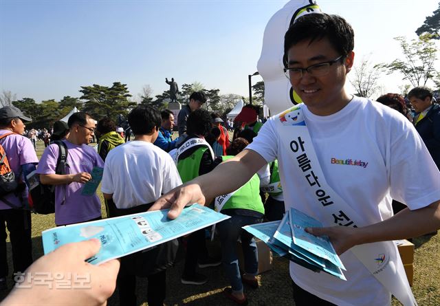 473회 한국일보 거북이마라톤 ‘제7회 전국동시지방선거 아름다운 선거를 위한 남산 걷기대회’가 21일 서울 남산공원 백범광장에서 열린 가운데 선관위 직원이 시민들에게 황사대비 마스크를 나눠주고 있다. 서재훈기자