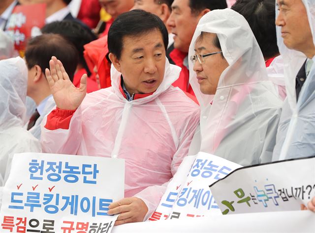 자유한국당 홍준표 대표(오른쪽)와 김성태 원내대표가 22일 국회 본청 앞 계단에서 열린 민주당원 댓글공작 규탄 및 특검촉구대회에서 대화 하고 있다. 연합뉴스