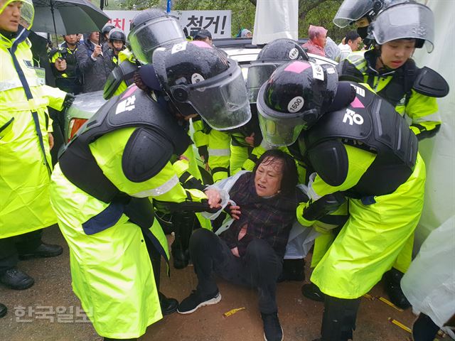 [저작권 한국일보]여결들이 23일 오전 성주군 초전면 소성리 사드기지 진입로인 진밭교에서 농성중이던 반대단체 회원을 끌어내고 있다. 김민규기자 whitekmg@hankookilbo.com