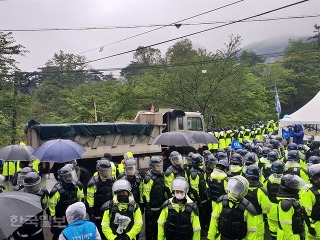 [저작권 한국일보]23일 오전 11시25분쯤 경북 성주군 초전면 소성리에서 사드기지 공사용 덤프트럭 등이 경찰 호위를 받아 기지로 진입하고 있다. 김민규기자 whitekmg@hankookilbo.com