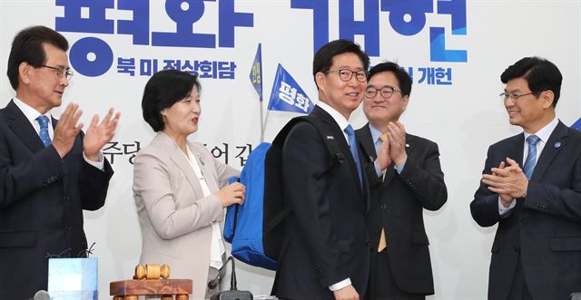 추미애 더불어민주당 대표가 20일 오전 국회에서 6.13 지방선거에 출마하는 양승조 충남지사 후보에게 민생 배낭을 메어주고 있다. 왼쪽부터 이시종 충북지사 후보, 추미애 대표, 양승조 충남지사 후보, 우원식 원내대표, 이춘희 세종시장 후보.