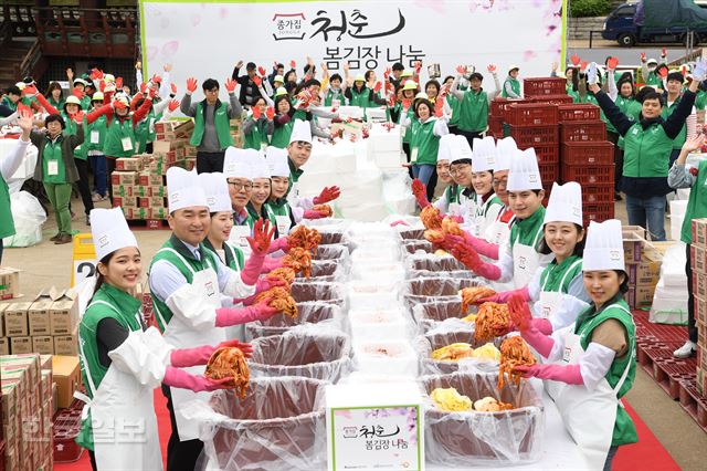 24일 오전 서울 중구 남산 한옥마을에서 열린 '2108 종가집 봄김장 나눔'행사에서 대상(주) 임정배 대표이사와 임직원, 대학생 자원봉사자들이 김치를 들고 환한 웃음을 짓고 있다. 이날 만든 김치는 2,018개의 나눔박스에 담겨 전국 저소득층에게 전달될 계획이다. 고영권 기자