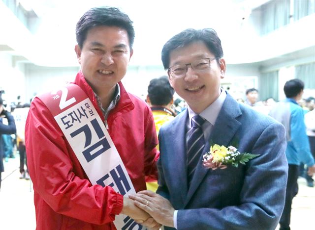 경남도지사 출마선언을 한 더불어민주당 김경수(오른쪽) 의원과 자유한국당 김태호 전 의원이 26일 오전 경남 김해 장유 스포츠센터에서 열린 김해시 아파트 관리직원 체육대회에 참석해 악수하고 있다. 연합뉴스