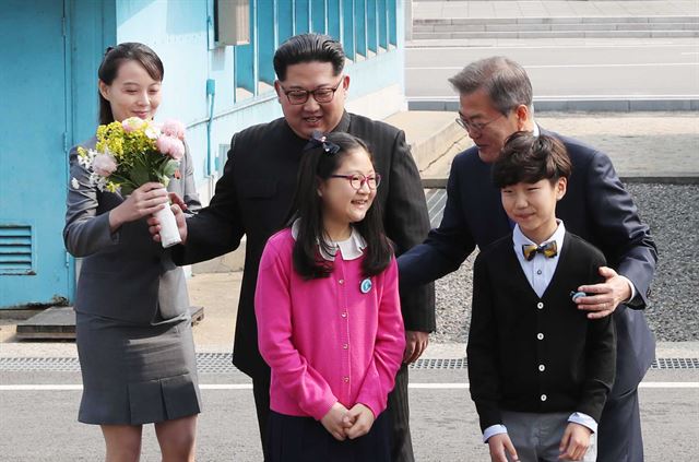 북한 김정은 국무위원장이 27일 오전 판문점에서 열린 정상회담에 앞서 화동에게 받은 환영 꽃다발을 김여정 당 중앙위 제1부부장에게 건네주고 있다. 판문점=고영권 기자