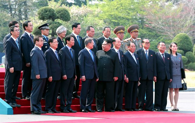 문재인 대통령과 김정은 북한 국무위원장이 27일 오전 판문점에서 수행원들과 기념사진 뒤 이야기를 나누고 있다. 판문점=고영권 기자