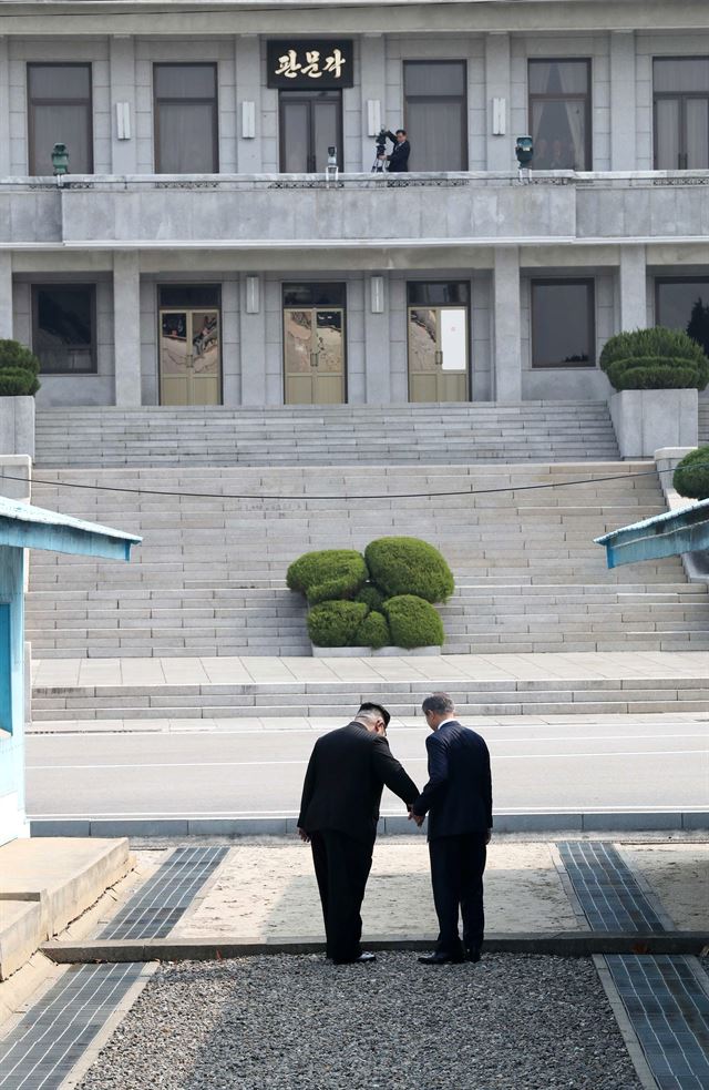 문재인 대통령과 김정은 북한 국무위원장이 판문점에서 만나 손을 잡고 군사분계선(MDL)을 넘고 있다. 고영권기자