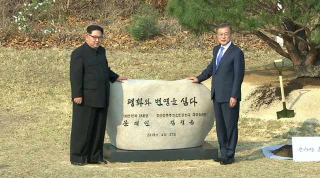 문재인 대통령과 김정은 북한 국무위원장이 27일 오후 판문점 군사분계선 인근 '소떼 길'에서 소나무 공동식수를 마친 뒤 표지석 앞에서 기념촬영을 하고 있다. 연합뉴스