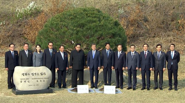 문재인 대통령과 김정은 북한 국무위원장이 27일 오후 판문점 군사분계선 인근 '소떼 길'에서 평화와 번영을 기원하는 소나무 공동식수를 마친 뒤 주요 참석자들과 기념촬영을 하고 있다. 연합뉴스