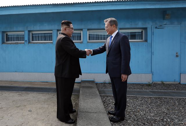 문재인 대통령과 김정은 국무위원장이 군사분계선에서 처음 만나 악수를 하고 있다. 판문점=고영권 기자