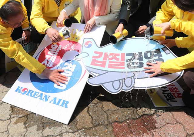 '땅콩회항' 피해자인 박창진 전 대한항공 사무장과 정의당 이정미 대표, 김종민 서울시장 후보 등이 25일 서울 강서구 대한항공 본사 앞에서 열린 정의당 정당연설회에서 황제경영 및 갑질경영을 규탄하며 손팻말에 물을 붓는 퍼포먼스를 하고 있다. 연합뉴스