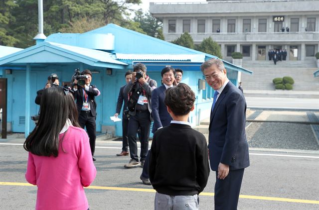 문재인 대통령은 전세계 이목이 집중된 역사적 순간을 앞두고도 주변을 살피는 것을 잊지 않았다. 27일 오전 판문점에서 문 대통령이 김정은 북한 국무위원장과의 역사적인 첫 만남에 앞서 화동들을 돌아보며 밝게 웃고 있다. 사진 오른쪽 위쪽으로 김 위원장 일행이 판문각을 나오는 모습이 보인다.