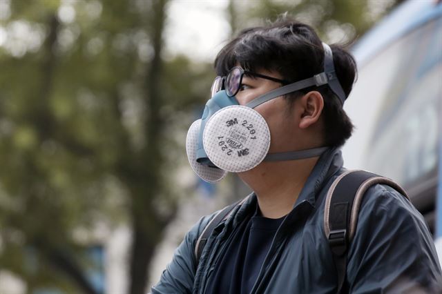 수도권 지역에 미세먼지 농도가 '한때나쁨' 수준을 보인 30일 오전 동대문구 경동시장 인근 버스정류장에서 방독마스크를 쓴 시민이 버스를 기다리고 있다.뉴스1