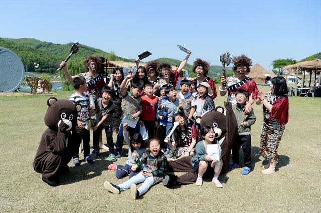 4일 충남 공주시 석장리 박물관 일원에서 열린 구석기 축제장을 찾은 어린이들이 분장한 행사요원과 사진촬영을 하며 즐거워 하고 있다. 공주시 제공