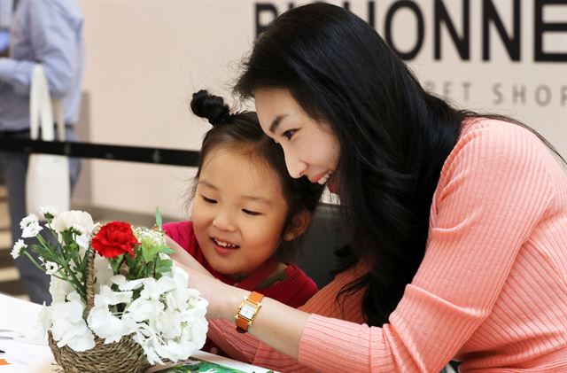 어버이날을 하루 앞둔 7일 오후 서울 여의도 IFC몰에서 어린이가 엄마와 함께 카네이션 꽃바구니를 만들고 있다. 뉴스1