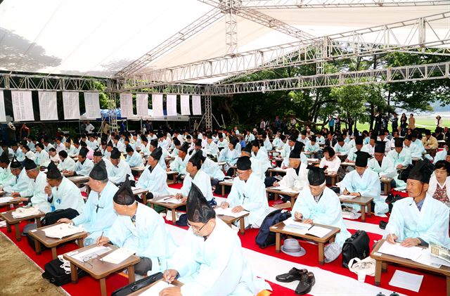 한복과 유건을 쓴 제25회 도산별과 재현행사 참가자들이 10일 오전 도산서원 앞에서 시상을 떠올리고 있다. 이번 행사에는 전국의 한시인과 시조인 등 250여 명이 참가했다. 안동시 제공