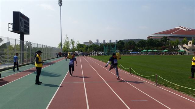 10일 경북 구미시 구미시민운동장에서 환경미화원을 뽑는 체력검정에 지원자들이 모래자루를 메고 사력을 다해 달리고 있다. 구미시 제공