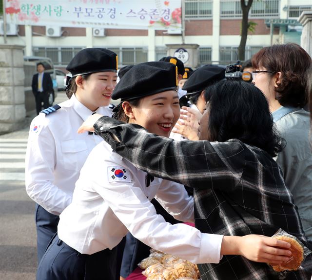 스승의 날인 15일 오전 서울 동대문구 정화여자상업고등학교에서 선생님들이 등교하는 학생과 포옹을 하고 있다. 정화여상은 이날 선생님들이 학생들에게 아침을 거른 학생들에게 빵을 나눠주고 포옹을 하며 스승의 날의 의미를 되새겼다. 뉴스1